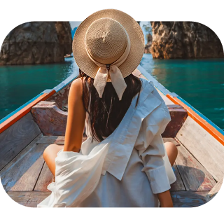Person sitting at the front of a wooden boat, surrounded by limestone cliffs and turquoise water, symbolizing serene and flexible travel experiences.