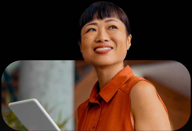 Smiling woman holding a tablet looking off in the distance