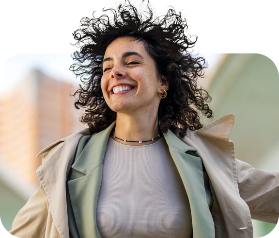 Woman smiling with her eyes closed while a strong wind blows her hair back